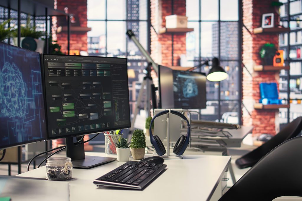 Empty office desk with computer screen showing terminal windows and network neurons. AI powered system uses cognitive computing and pattern recognition for futuristic software solutions.